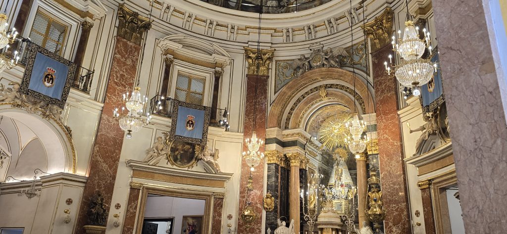 Ornate interior of Valencia Cathedral with chandeliers, marble columns and religious artwork in Valencia, Spain