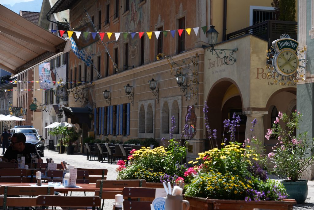 Outdoor café tables and flower displays on a street in Garmisch-Partenkirchen