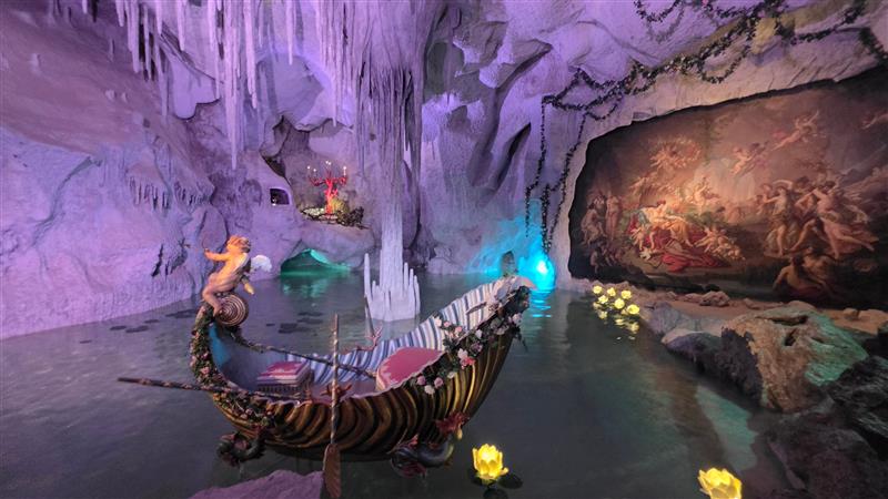 Colourfully lit artificial grotto with a decorative boat at Linderhof Palace